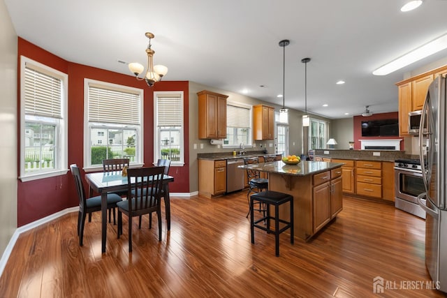 55 Dahlia Ct, Piscataway, NJ 08854 - kitchen with stainless steel appliances, a center island, a kitchen bar, a chandelier, and dark wood-type flooring