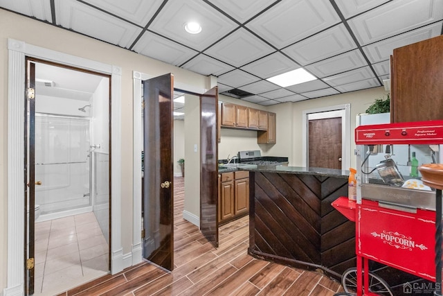 kitchen with a paneled ceiling and hardwood / wood-style floors