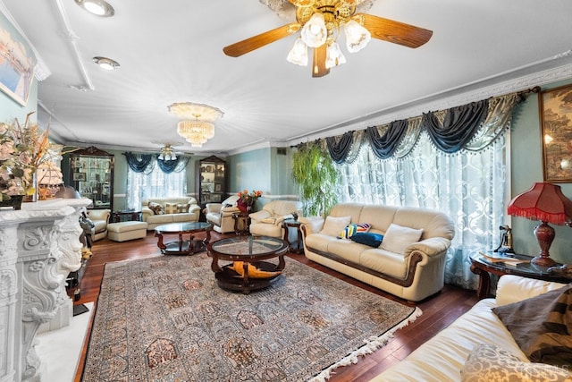 living room featuring ornamental molding, dark hardwood / wood-style flooring, and ceiling fan with notable chandelier