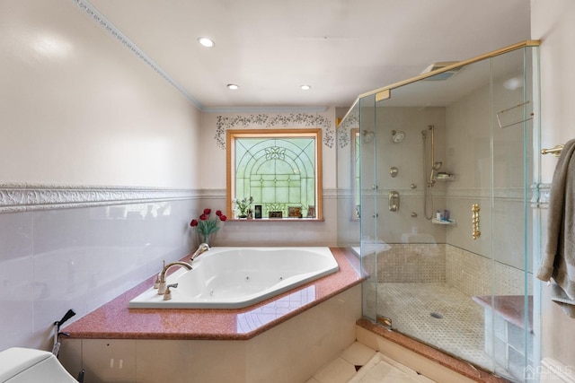 bathroom with tile walls, independent shower and bath, and toilet