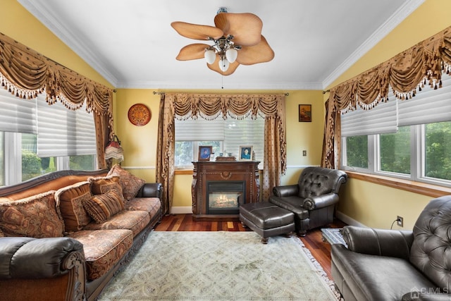 living room with hardwood / wood-style floors, crown molding, and ceiling fan