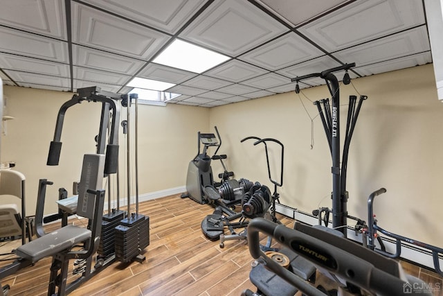 exercise room with baseboards and wood finish floors