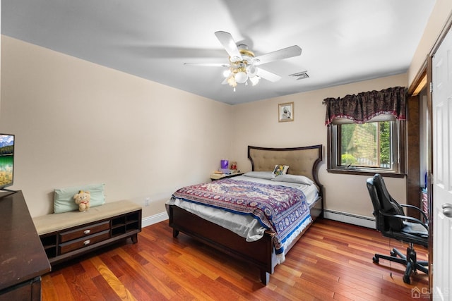 bedroom with baseboard heating, ceiling fan, and hardwood / wood-style floors