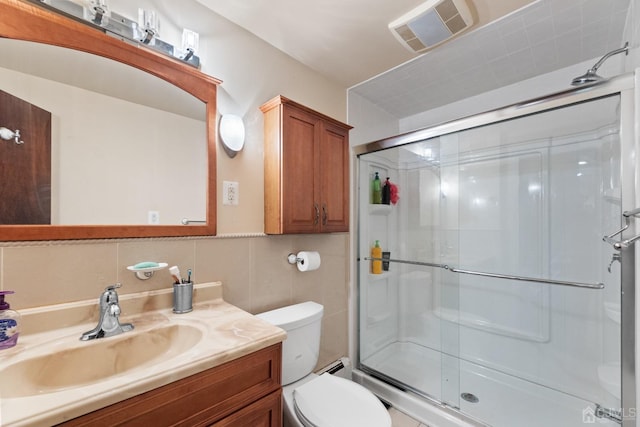 bathroom with vanity, an enclosed shower, toilet, and tile walls