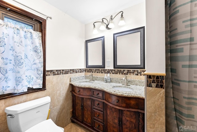 bathroom featuring vanity, tile walls, and toilet