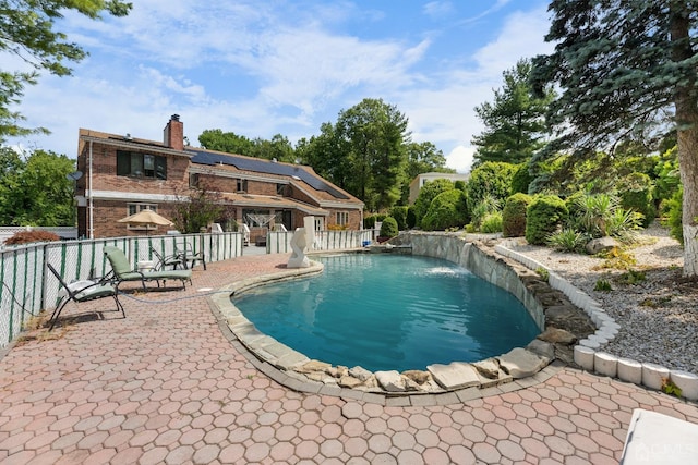 view of swimming pool featuring pool water feature and a patio