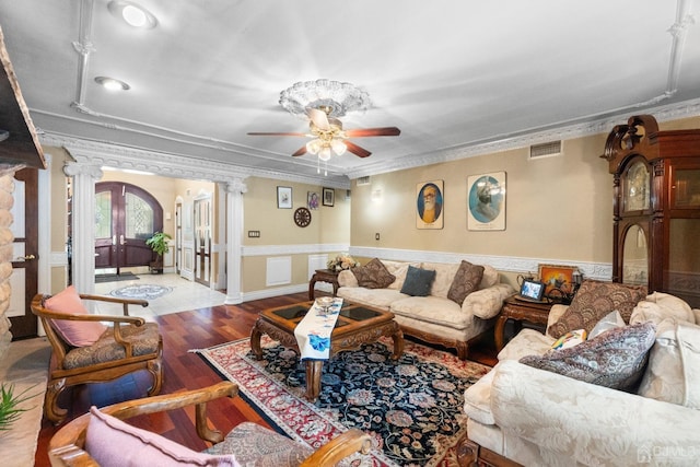 living room featuring ornate columns, hardwood / wood-style flooring, ceiling fan, crown molding, and french doors