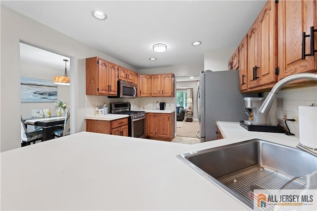 34 Connor Ave, Metuchen, NJ 08840 - kitchen with appliances with stainless steel finishes, decorative backsplash, light countertops, brown cabinets, and recessed lighting