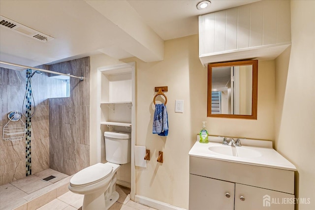 bathroom with tiled shower, vanity, toilet, and tile patterned floors