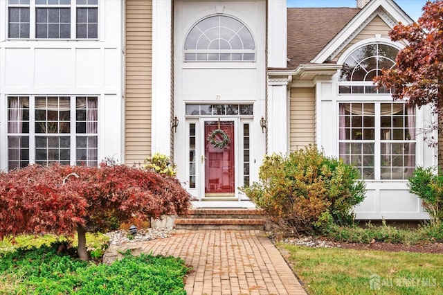 entrance to property with a shingled roof