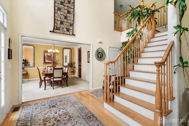 foyer featuring hardwood / wood-style floors, a chandelier, and a high ceiling