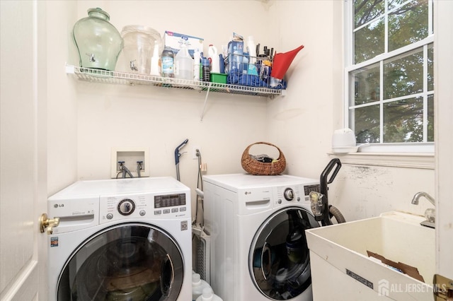 washroom with washer and dryer, laundry area, and a sink