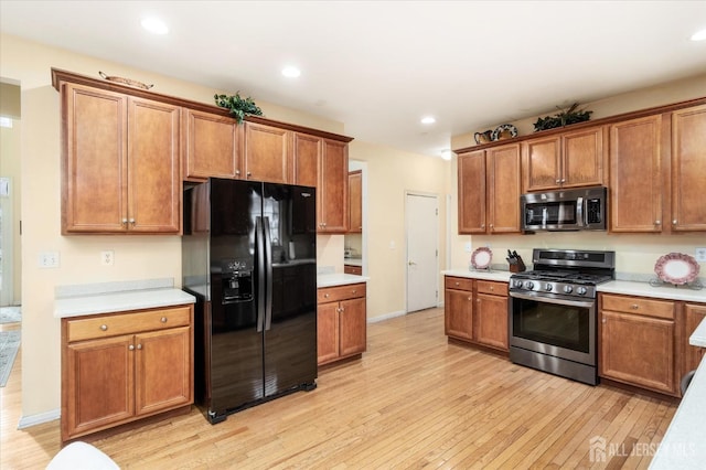 kitchen featuring recessed lighting, stainless steel appliances, light countertops, light wood-type flooring, and brown cabinetry