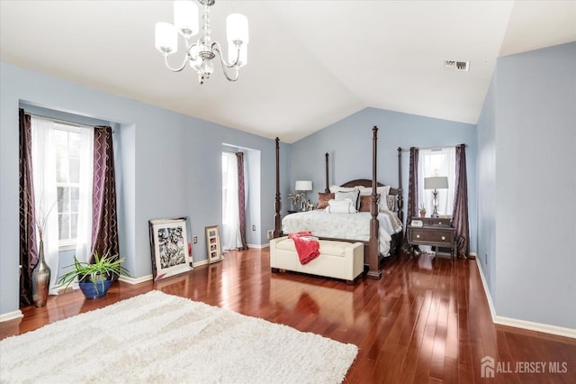 bedroom with dark wood-style floors, lofted ceiling, a chandelier, and visible vents