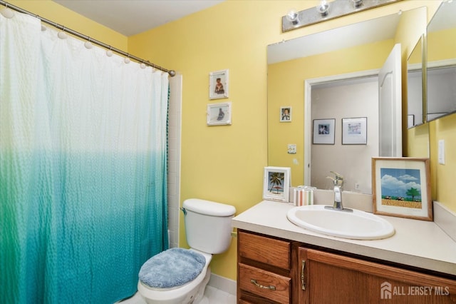 bathroom featuring a shower with shower curtain, vanity, and toilet