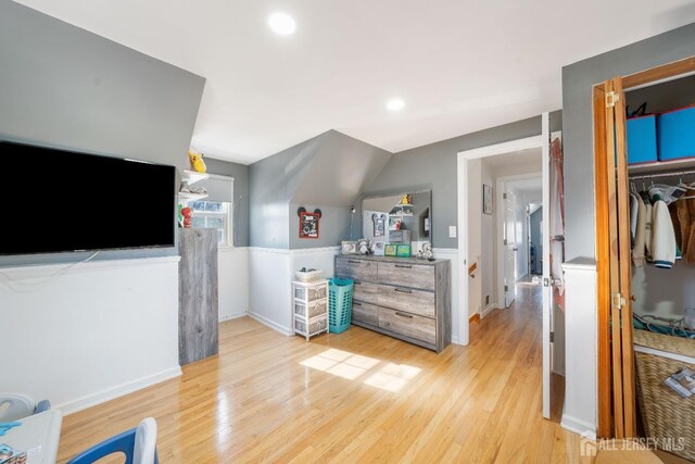 bedroom featuring vaulted ceiling and light wood-type flooring