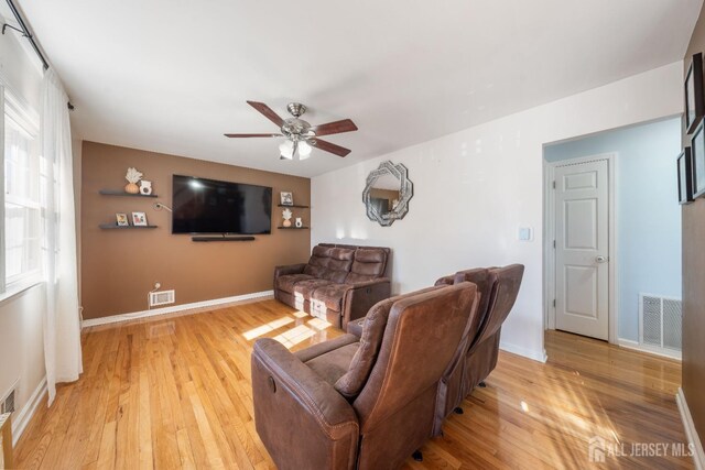 living room featuring ceiling fan and light hardwood / wood-style flooring