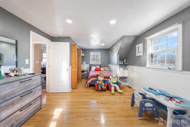 bedroom with light hardwood / wood-style floors and multiple windows