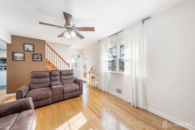 living room with ceiling fan and light hardwood / wood-style flooring