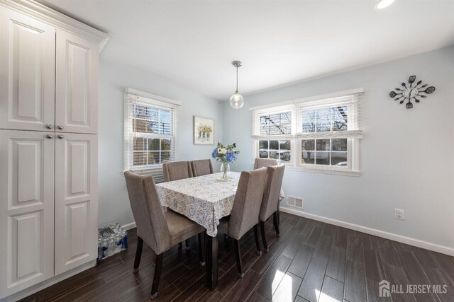 dining area featuring dark wood-type flooring