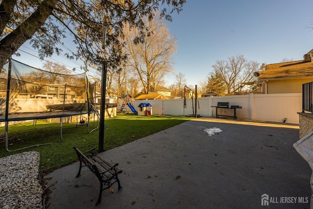 view of yard featuring a playground, a patio area, and a trampoline