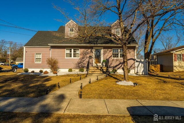 cape cod home with a front lawn