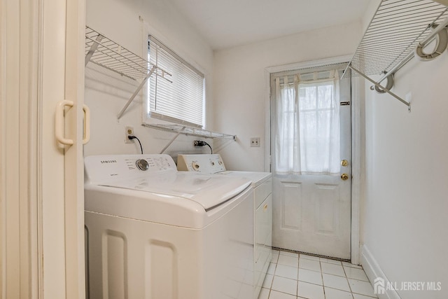 clothes washing area featuring washing machine and dryer and light tile patterned floors