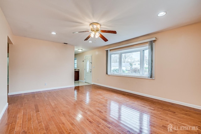 spare room featuring ceiling fan, light wood-type flooring, baseboards, and recessed lighting