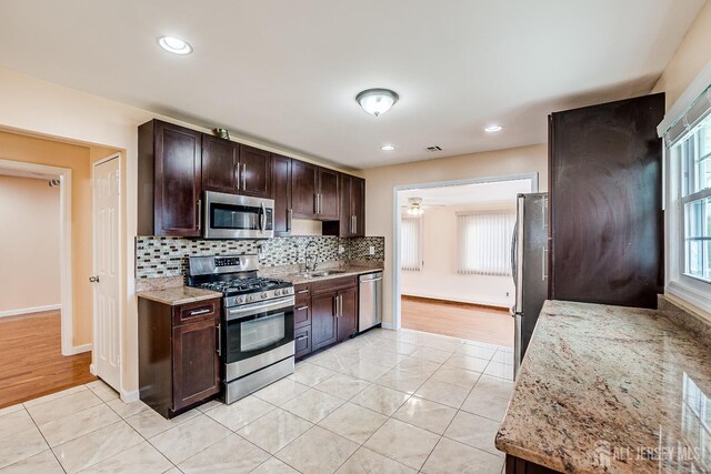 kitchen with stainless steel appliances, light tile patterned flooring, dark brown cabinetry, decorative backsplash, and recessed lighting