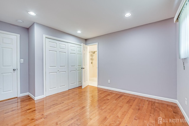 unfurnished bedroom with light wood finished floors, baseboards, recessed lighting, and a closet