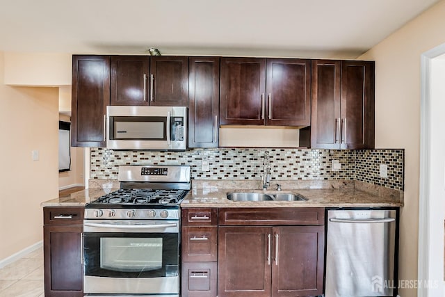 kitchen with stainless steel appliances, a sink, dark brown cabinetry, and backsplash