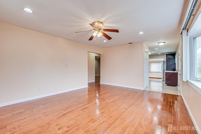 unfurnished room with ceiling fan, light wood-style flooring, baseboards, and recessed lighting