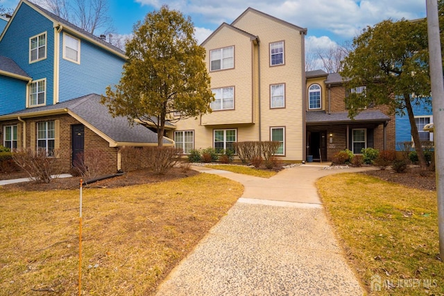 view of front facade featuring a front lawn and brick siding