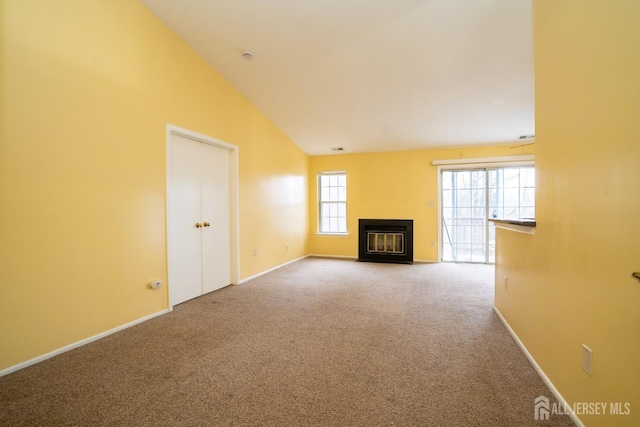 unfurnished living room with high vaulted ceiling, a fireplace with flush hearth, baseboards, and carpet flooring