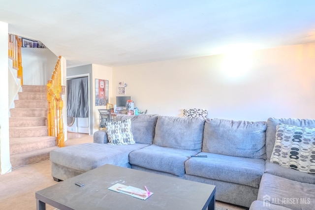 living area featuring stairway and light colored carpet