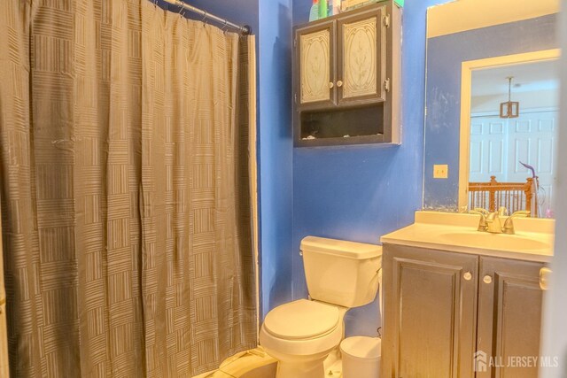 bathroom featuring a shower with curtain, vanity, and toilet