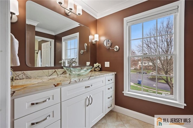 bathroom featuring crown molding, baseboards, plenty of natural light, and vanity