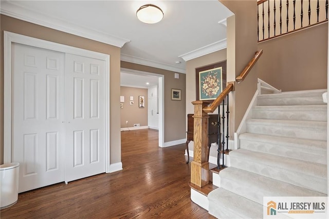 entrance foyer with crown molding, dark wood-style flooring, baseboards, and stairway