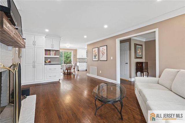 living room featuring crown molding, dark wood-type flooring, recessed lighting, and baseboards