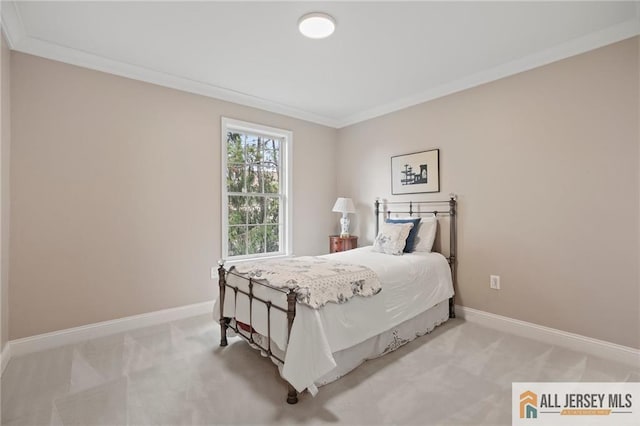 bedroom with light colored carpet, ornamental molding, and baseboards