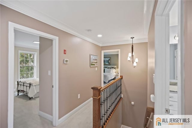 hall featuring an upstairs landing, ornamental molding, a chandelier, baseboards, and light carpet
