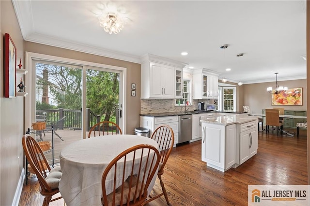 kitchen with stainless steel dishwasher, a chandelier, a sink, dark wood finished floors, and ornamental molding