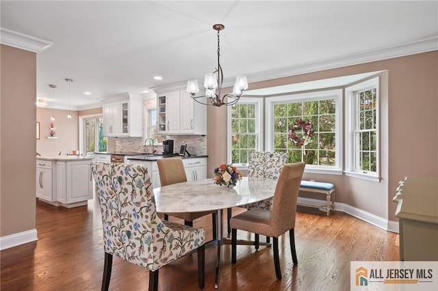 dining area featuring ornamental molding, baseboards, a chandelier, plenty of natural light, and dark wood-style floors