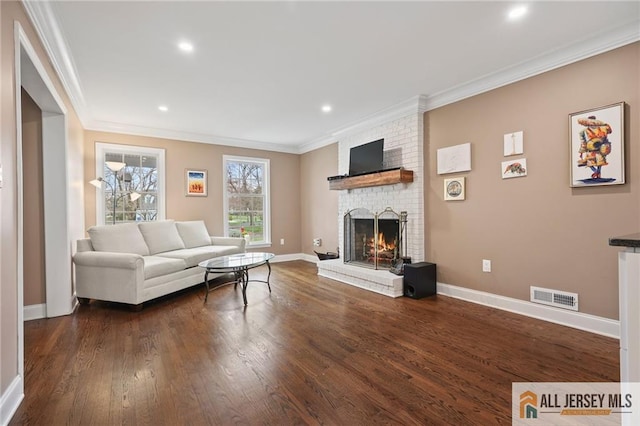 living area with ornamental molding, a fireplace, wood finished floors, baseboards, and recessed lighting