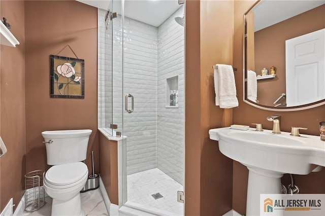 bathroom featuring toilet, a stall shower, and marble look tiles