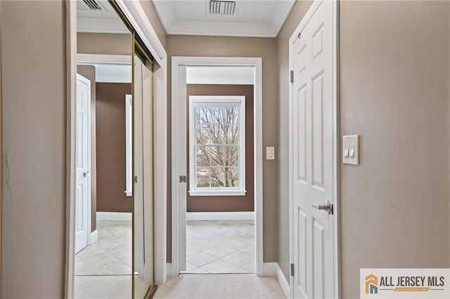 hallway featuring light tile patterned flooring, baseboards, and crown molding