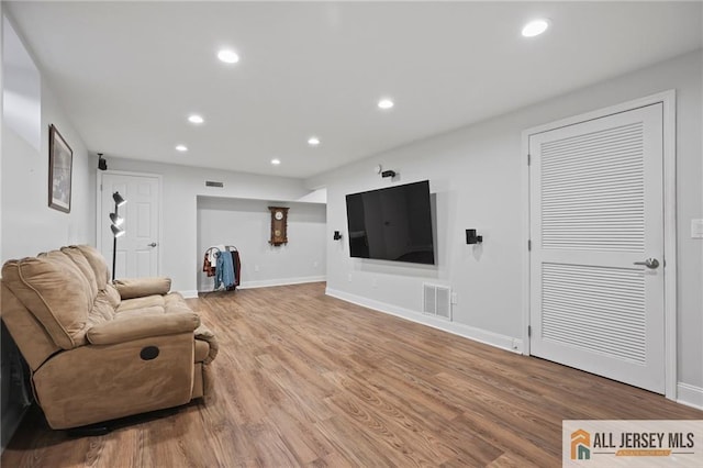 living area featuring recessed lighting, light wood-type flooring, and baseboards