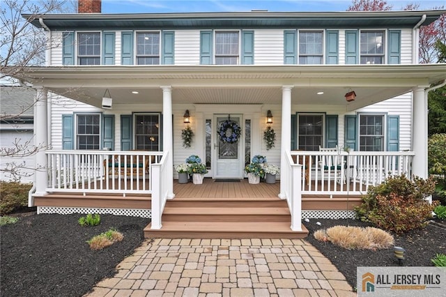 view of front of property featuring a chimney and covered porch