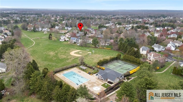 aerial view of property's location with a pool area and nearby suburban area