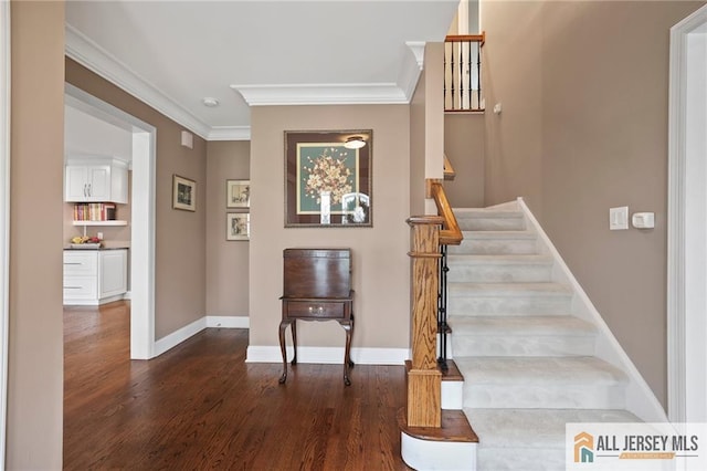 stairs with crown molding, wood finished floors, and baseboards